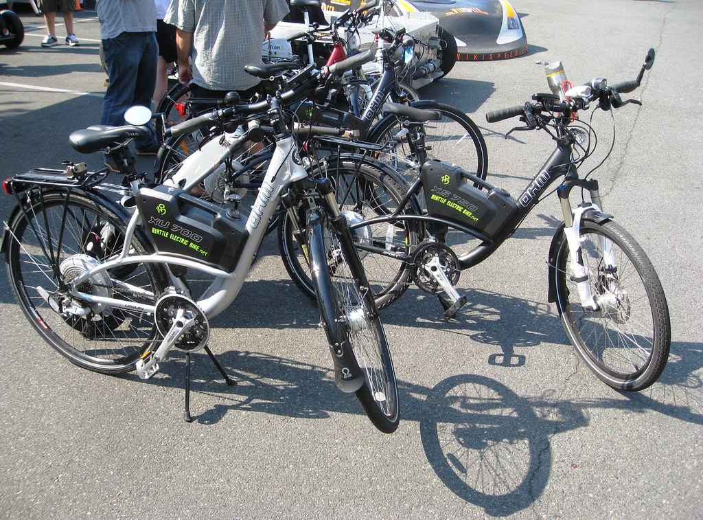 Several electric bicycles parked on a road top.